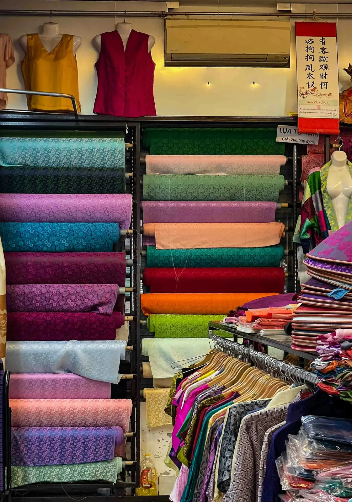 A shop selling both fabric rolls and ready-made clothes